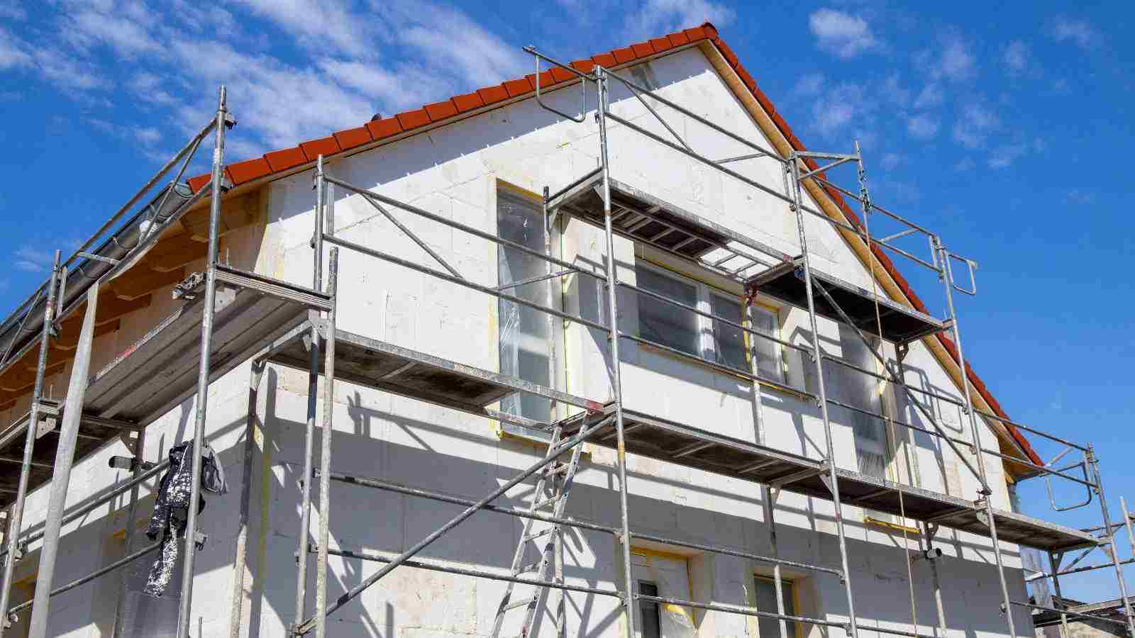 Haussanierung in Stuttgart: Ein Einfamilienhaus mit Gerüst, vorbereitet für energetische Modernisierung und Fassadensanierung.